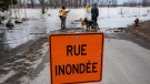 People look at the rising waters of the Milles-Iles river in Laval, Que., Tuesday, April 18, 2023. Regions across the province are on increased flood alert as the spring thaw continues. THE CANADIAN PRESS/Ryan Remiorz