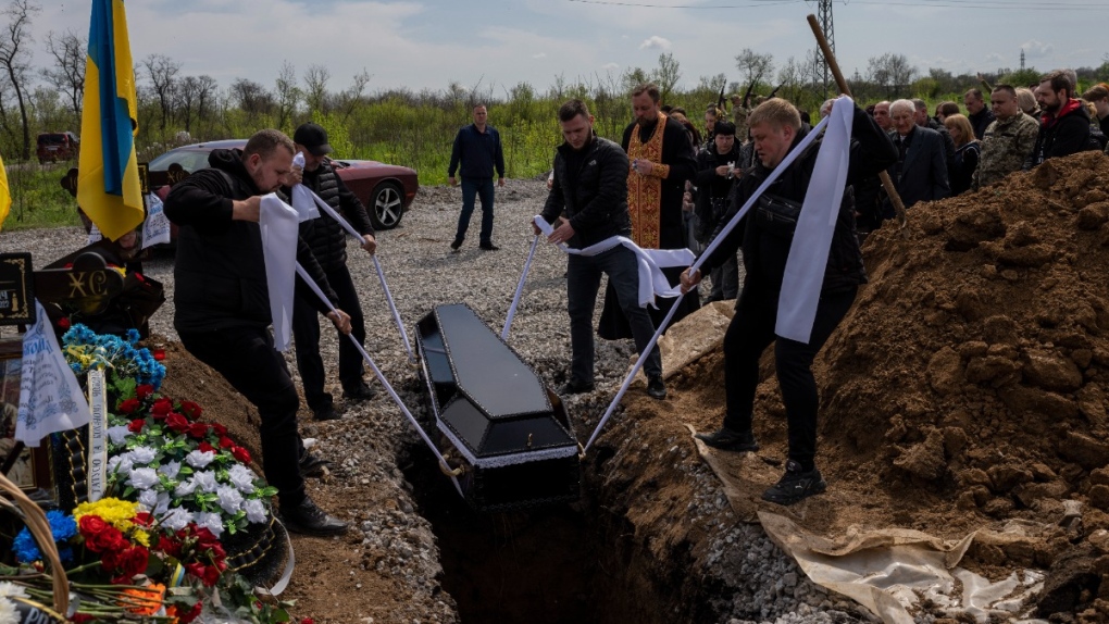 Undertakers lower coffin of Ukrainian servicemen