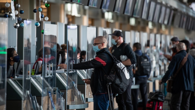 In this file photo, passengers check in for flights to the U.S. at Vancouver International Airport, in Richmond, B.C., on Thursday, December 2, 2021. THE CANADIAN PRESS/Darryl Dyck