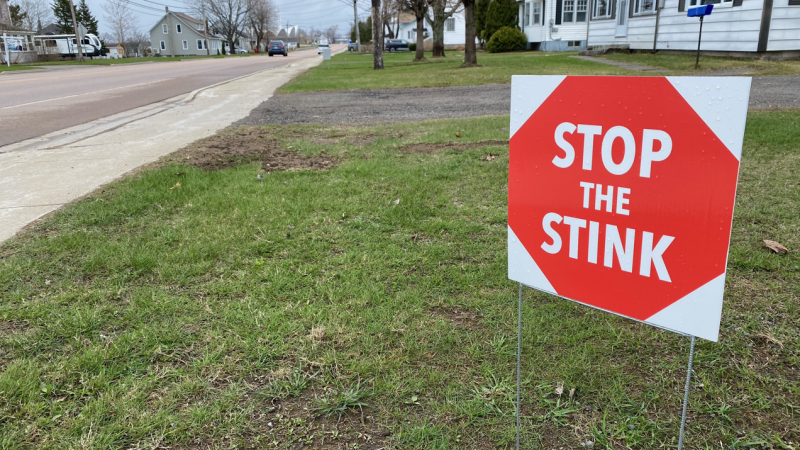 Miniature stop signs with the slogan "Stop the Stink" can be seen at several homes around Beaurivage, N.B. (Derek Haggett/CTV Atlantic)