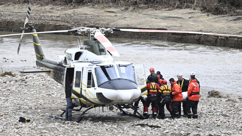 Rescuers carry a firefighter's body