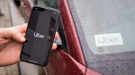 The Uber app is seen on an iPhone near a driver's vehicle after the company launched service, in Vancouver, Friday, Jan. 24, 2020. THE CANADIAN PRESS/Darryl Dyck