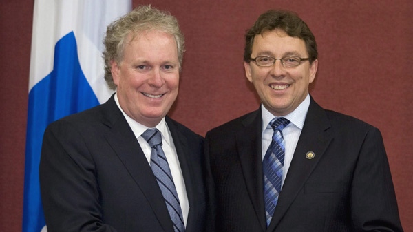 Quebec Premier Jean Charest, left, poses with newly sworn in member for Riviere-du-Loup, Jean D'Amour, during a ceremony Wednesday Aug. 12, 2009 at the Quebec legislature. (Jacques Boissinot / THE CANADIAN PRESS)