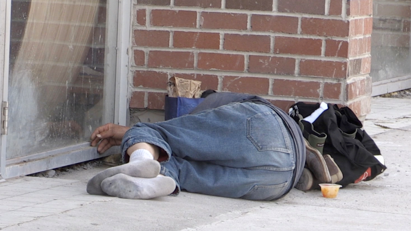 A man sleeps on Dundas Street in the Old East Village on May 12, 2023. (Daryl Newcombe/CTV News London)