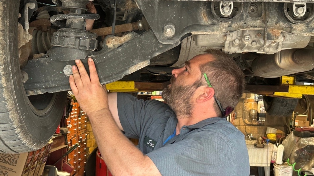 Mechanic Jon Guthrie inspects a 2014 SUV