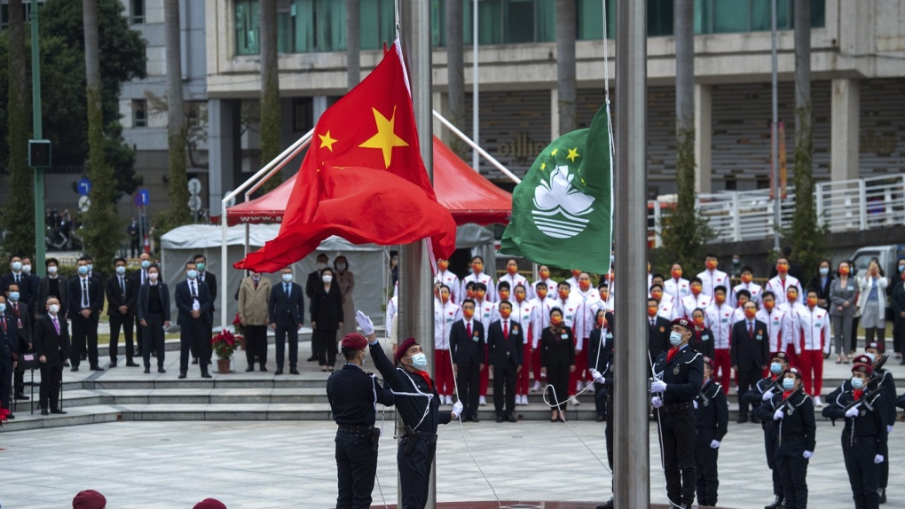 policemen perform a flag raising ceremony in Macao