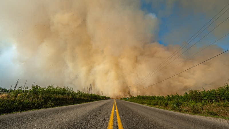 Smoke from a wildfire is shown crossing a road in British Columbia in this undated handout image provided by the BC Wildfire Service. THE CANADIAN PRESS/HO-BC Wildfire Service