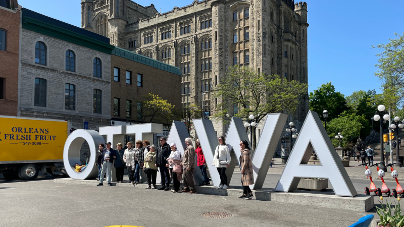 People get their picture taken at the Ottawa sign on York Street. May 22, 2023. (Ted Raymond/CTV News Ottawa)
