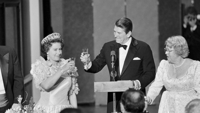 U.S. President Ronald Reagan and Queen Elizabeth II raise their glasses in a toast during a state dinner, March 3, 1983, at the M. H. de Young Museum in San Francisco's Golden Gate Park. Woman at right is unidentified. (AP Photo/Ed Reinke, File)