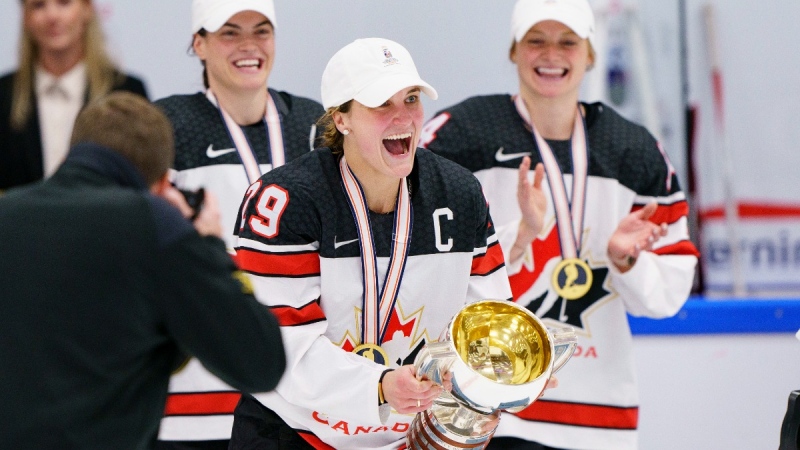 Canada's Marie-Philip Poulin, centre, receives the trophy after the IIHF World Championship Woman's ice hockey gold medal match between U.S.A. and Canada in Herning, Denmark, Sept. 4, 2022. (Bo Amstrup/Ritzau Scanpix via AP)