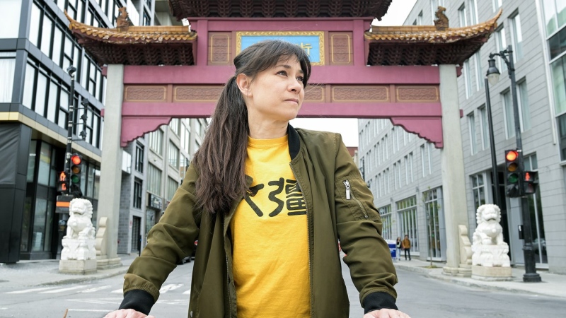 Karen Cho, director of Big Fight in Little Chinatown, poses next to the entrance to Chinatown in Montreal, Saturday, May 20, 2023. Chinatowns across North America don't just share a similar look — they also face similar existential threats, and similar David-versus-Goliath-like battles for survival. THE CANADIAN PRESS/Graham Hughes.
