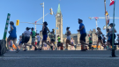 Runners in the Tamarack Ottawa Race Weekend half marathon run past Parliament Hill on Sunday morning. (Jackie Perez/CTV News Ottawa)