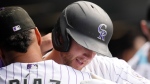 Colorado Rockies' Elias Diaz, left, hugs Ryan McMahon who returns to the dugout after hitting a two-run home run off New York Mets relief pitcher Stephen Nogosek in the fifth inning of a baseball game Sunday, May 28, 2023, in Denver. (AP Photo/David Zalubowski)