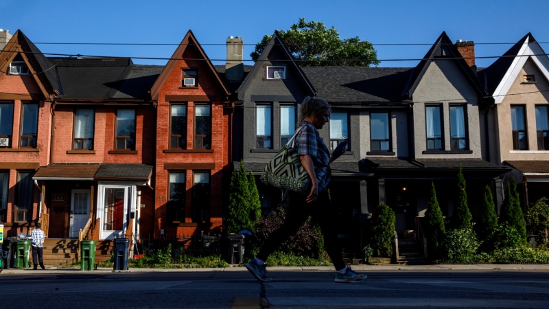 A person walks by a row of houses in Toronto on Tuesday July 12, 2022. THE CANADIAN PRESS/Cole Burston
