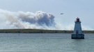 A water bomber tops up near the Sandy Point Lighthouse as a wildfire rages in Shelburne County, N.S.