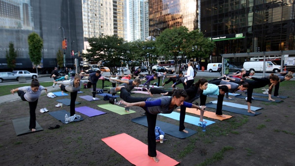A group of people participate in a free outdoor yoga class to mark the opening of a yoga centre in downtown Vancouver, B.C., on Thursday, September 10, 2009. (Darryl Dyck / THE CANADIAN PRESS)