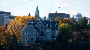 The Canadian prime ministers' residence, 24 Sussex, is seen on the banks of the Ottawa River in Ottawa on Monday, Oct. 26, 2015. The Parliament Hill Peace Tower is in the distance. THE CANADIAN PRESS/Sean Kilpatrick
