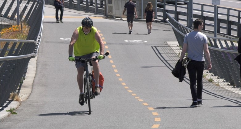 A cyclist rides on a protected bike lane on Victoria’s Johnson Street Bridge on May 29, 2023. (CTV News)