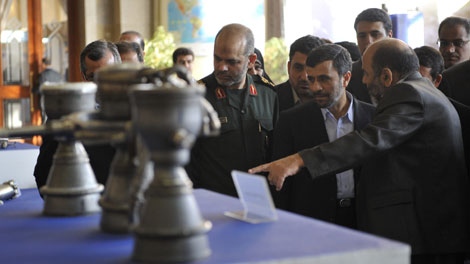 Iranian President Mahmoud Ahmadinejad, second right, listens to an unidentified official as he views part of a domestically-built satellite booster rocket with his Defense Minister Gen. Ahmad Vahidi, at center, in Tehran, Iran, Wednesday, Feb. 3, 2010. (AP Photo)