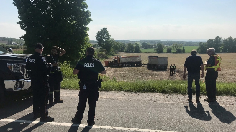 A dump truck with an extension ended up down an embankment in a farmer's field following a crash in Barrie, Ont., on Tues., May 30, 2023. (CTV News/David Sullivan) 

