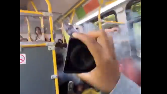 A young male is seen holding what appears to be a lit firework inside a TTC bus. (6ixBuzzTV screengrab)