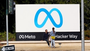 People talk near a Meta sign outside of the company's headquarters in Menlo Park, Calif., March 7, 2023. (AP Photo/Jeff Chiu)
