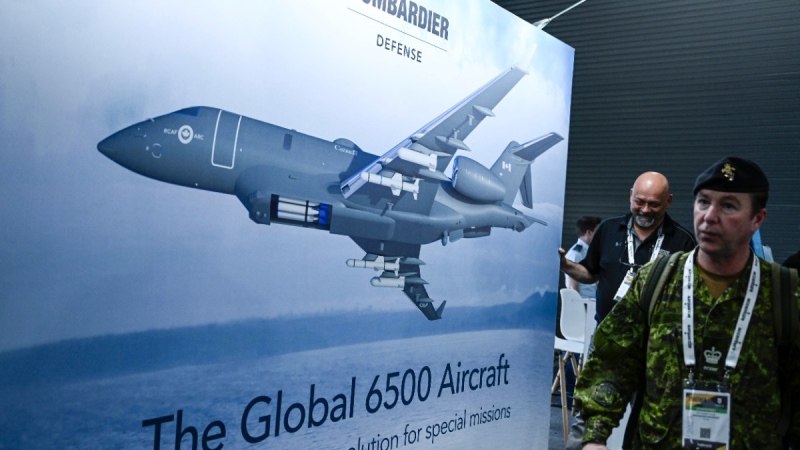 Attendees pass an image of the Bombardier Global 6500 Aircraft at the CANSEC trade show, billed as North America’s largest multi-service defence event, in Ottawa, May 31, 2023. THE CANADIAN PRESS/Justin Tang