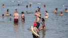 People cool down in the St. Lawerence River as temperatures soar in Montreal, Sunday, August 22, 2021. THE CANADIAN PRESS/Graham Hughes
