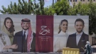 A poster with pictures of Crown Prince Hussein and his fiancee, Saudi architect Rajwa Alseif is posted at a road in Amman, Jordan, Wednesday, May 31, 2023. (AP Photo/Nasser Nasser)