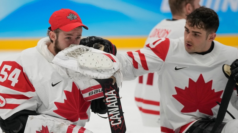 Canada's goalkeepr Adam Kingsmill, left, reacts after being defeated by United States during their para ice hockey finals match at the 2022 Winter Paralympics, Sunday, March 13, 2022, in Beijing. (AP Photo/Dita Alangkara)