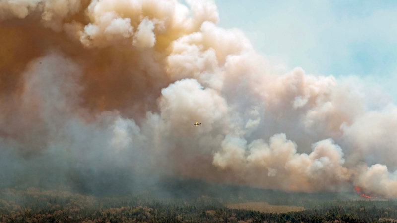 An aircraft disperses a mix of water and fire retardant over a fire near Barrington Lake in Shelburne County, N.S. in this Wednesday, May 31, 2023 handout photo.THE CANADIAN PRESS/HO-Communications Nova Scotia 