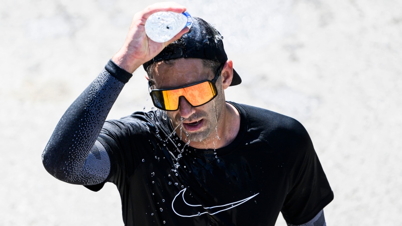 Jonathan Bond of Quebec City pours water on his head after finishing the marathon of the Ottawa Race Weekend in Ottawa, on Sunday, May 28, 2023. (THE CANADIAN PRESS/Justin Tang)