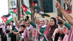 Jordanians wave flags in anticipation of the royal motorcade in Amman, Jordan, on June 1, 2023. (Raad Adayleh / AP) 