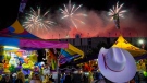 A visitor watches the fireworks display from the midway at the Calgary Stampede in Calgary, Saturday, July 9, 2016. THE CANADIAN PRESS/Jeff McIntosh