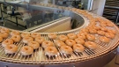 Glazed doughnuts roll by on a conveyer belt at a Krispy Kreme store in Charlotte, N.C., Thursday, Dec. 6, 2007. (AP Photo/Chuck Burton)