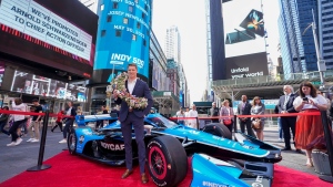 Josef Newgarden poses for photos after ringing the opening bell at the Nasdaq MarketSite, Tuesday, May 30, 2023, in New York. (AP Photo/Mary Altaffer)