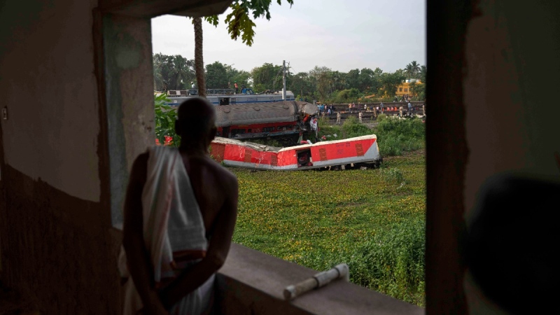 A person watches from the balcony of his house at the site where trains derailed, in Balasore district, in the eastern Indian state of Orissa, June 4, 2023. (AP Photo/Rafiq Maqbool)