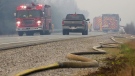 A fire hose lies along highway 103 while fire crews work on wildfire flareups near Shelburne, Nova Scotia, N.S. in this Saturday, June 3, 2023 handout photo. THE CANADIAN PRESS/HO-Communications Nova Scotia