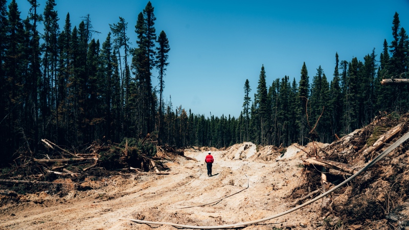 A fire fighter walks down a dirt road near Chapais, in Northern Quebec, on Friday June 2, 2023 in this image provided by the fire prevention agency known as SOPFEU. THE CANADIAN PRESS/HO-SOPFEU Prevention and Communications-Audrey Marcoux
