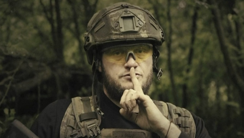 In this image made from video provided by Ukrainian Defense Ministry on Sunday, June 4, 2023, a Ukrainian soldier poses for the camera with his fingers to his lips, in an undisclosed location in Ukraine. (Ukrainian Defense Ministry via AP)