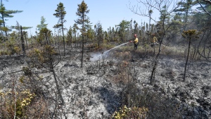 Department of Natural Resources and Renewables firefighters Walter Scott (left) and Zac Simpson work on a fire in Shelburne County, N.S. in a Thursday, June 1, 2023 handout photo. THE CANADIAN PRESS/HO-Communications Nova Scoti