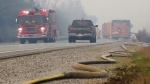 A fire hose lies along Highway 103 while fire crews work on wildfire flareups near Shelburne, N.S., June 3, 2023. THE CANADIAN PRESS/HO-Communications Nova Scotia