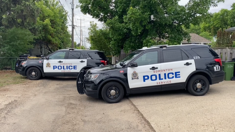Police tape and vehicles block access to a back alley at 76 Street and 105 Avenue on June 5, 2023. A robbery was reported at 10520 76 St. NW that morning and police found an injured person, who soon died, when they arrived. 