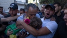 Palestinian Hussein al-Tamimi carries the body of his 2 1/2 year old nephew Mohammed al-Tamimi upon his arrival at the Palestine Medical Complex, in the West Bank city of Ramallah, June 5, 2023. (AP Photo/Nasser Nasser)