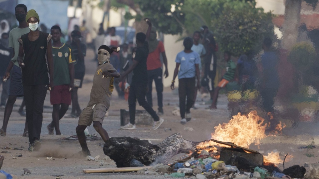 A demonstrator throws a rock at police