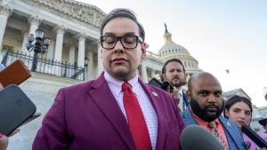 Rep. George Santos, R-N.Y., speaks to reporters outside the Capitol, as his top political aide Vish Burra, second from right, listens, after an effort to expel Santos from the House, in Washington, Wednesday, May 17, 2023. (AP Photo/J. Scott Applewhite, File)