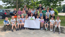 Grade 1 & 2 students at Guthrie Public School in Oro Station, Ont., are pictured alongside their teachers holding a cheque for Street Cats Rescue. (Supplied)