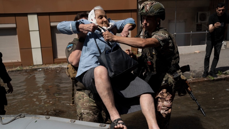 A woman is evacuated from a flooded neighbourhood in Kherson, Ukraine, on June 7, 2023. (Roman Hrytsyna / AP) 
