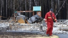 A firefighter walks past a home destroyed by a wildfire in Hammond's Plains, N.S., during a media tour, Tuesday, June 6, 2023. (THE CANADIAN PRESS/POOL, Tim Krochak)
