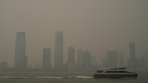 Buildings in Jersey City, N.J. are partially obscured by smoke from Canadian wildfires as a ferry travels up the Hudson River, seen from the Manhattan borough of New York on Tuesday, June 6, 2023. (Patrick Sison/AP)